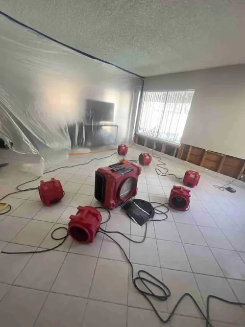 Air scrubber running inside a plastic containment barrier in a family room