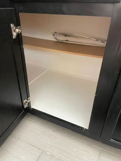 Sink cabinet emptied and dried after a supply-line leak