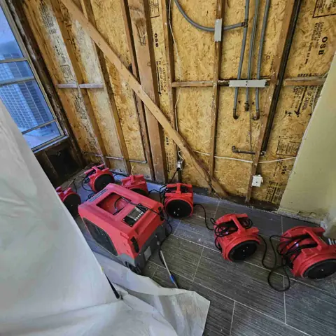 Dehumidifier and air movers drying exposed wall framing