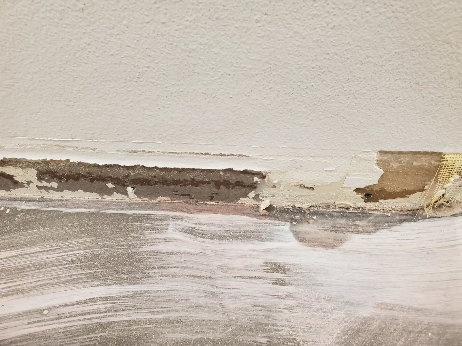 Water-damaged drywall along the floor line