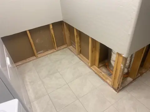 Flood cuts along a tiled room with the wall cavity drying