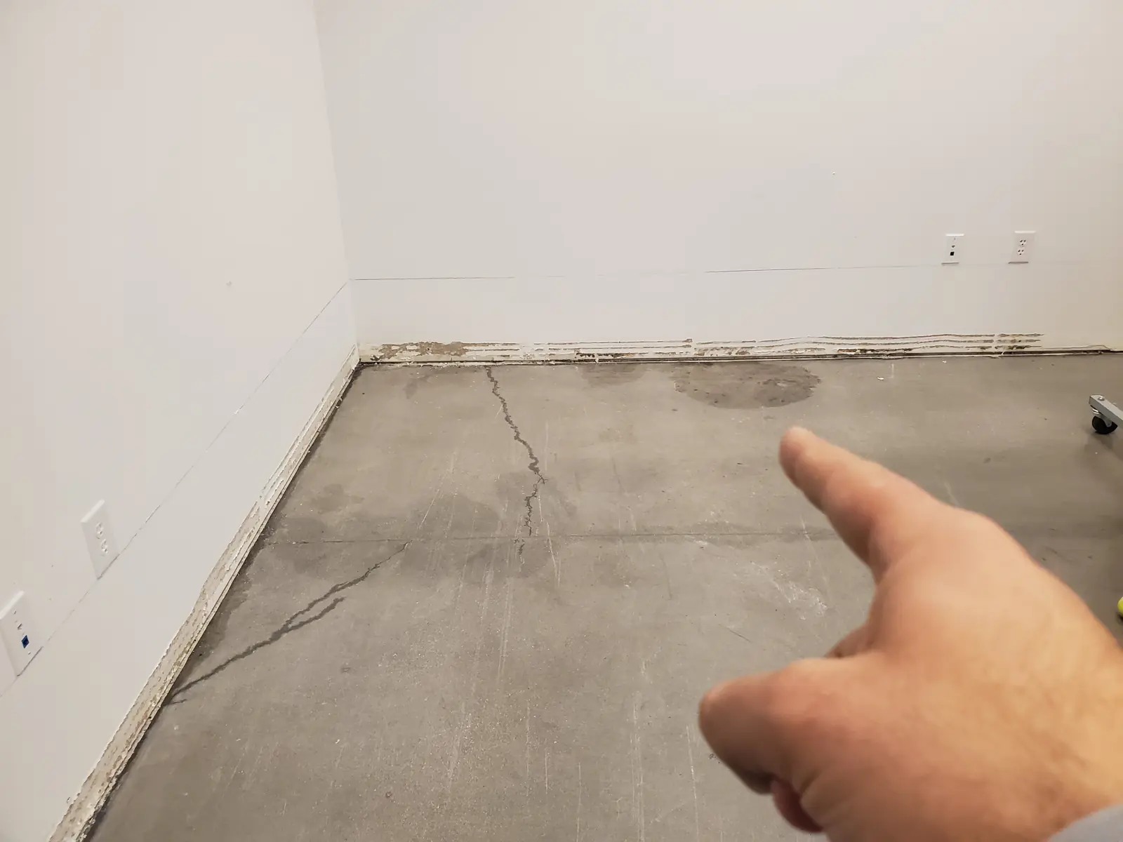 Técnico señalando una mancha de agua en una losa de concreto