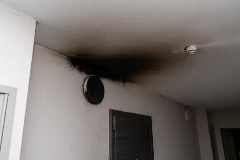 Smoke and soot damage on an interior wall and ceiling